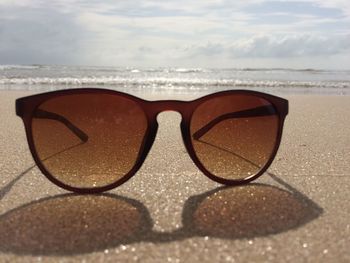 Close-up of sunglasses on beach