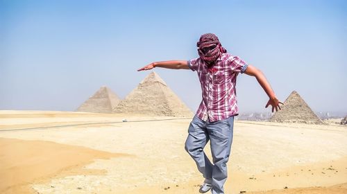 Man standing on desert against clear sky