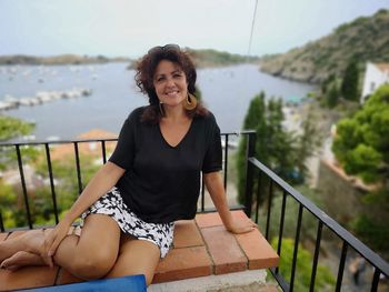 Portrait of woman sitting against sea