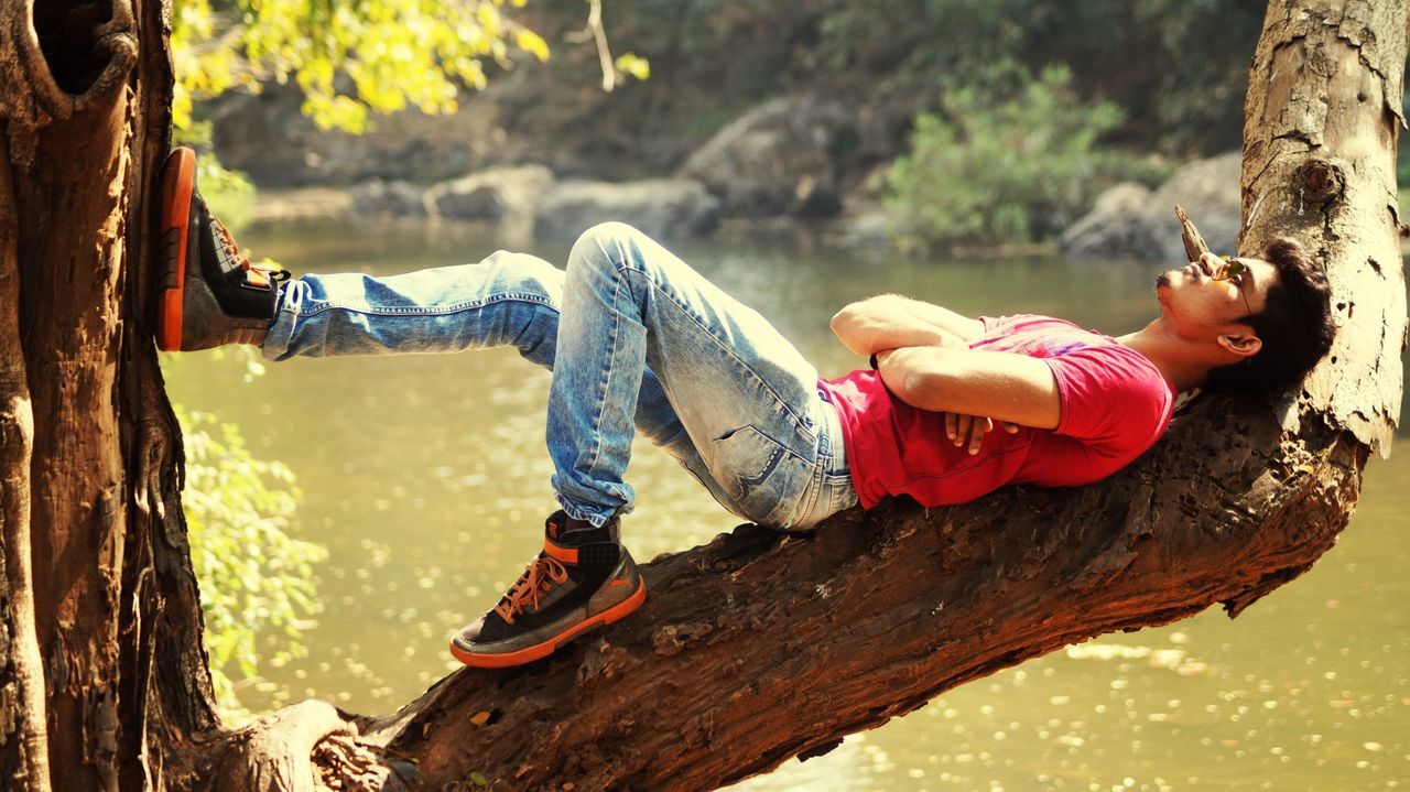 water, full length, leisure activity, rock - object, tree, lifestyles, rock formation, nature, rear view, men, holding, day, outdoors, lake, beauty in nature, sitting, standing, wood - material