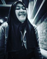 Portrait of smiling young woman standing at night