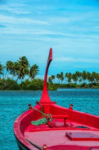 Red boat on beach against sky