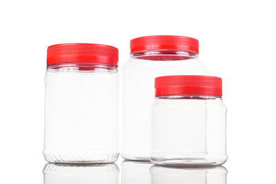 Close-up of empty glass jars against white background