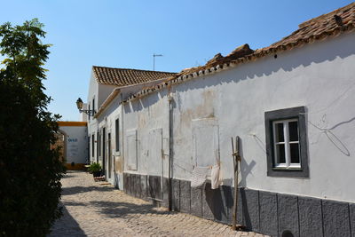 Footpath amidst buildings against sky
