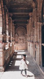 Girl standing on corridor of historical building