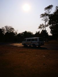 Car parked on street in field against sky