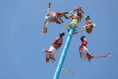 Low angle view of kites flying against clear sky