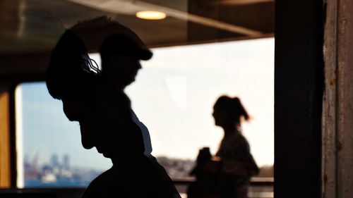 Portrait of silhouette people standing against window