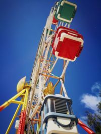 Low angle view of ferris wheel against blue sky