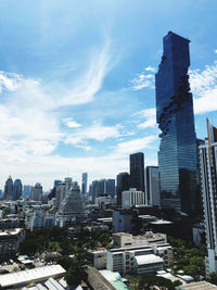 Buildings in city against cloudy sky