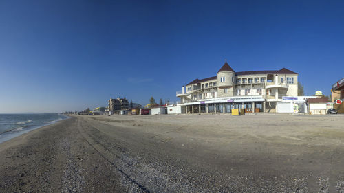 Buildings at beach against blue sky