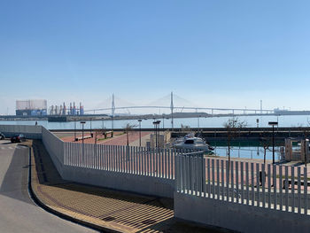 Bridge over river in city against clear sky