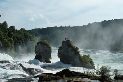 Scenic view of waterfall against sky