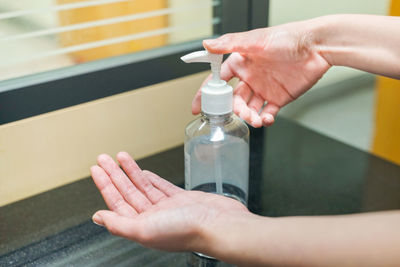 Close-up of hand holding glass bottle