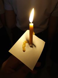 High angle view of lit candle on paper