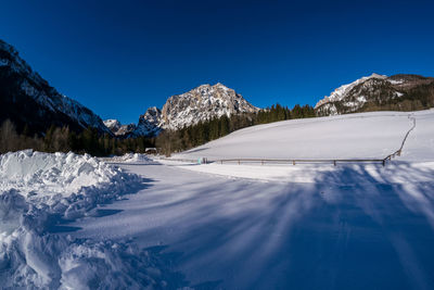 Panoramic view of snowcapped mountains against clear blue sky