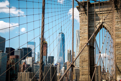 View of suspension bridge in city against sky