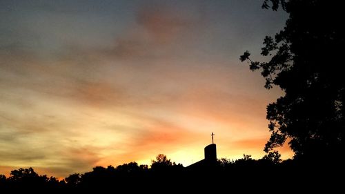 Low angle view of silhouette trees against dramatic sky