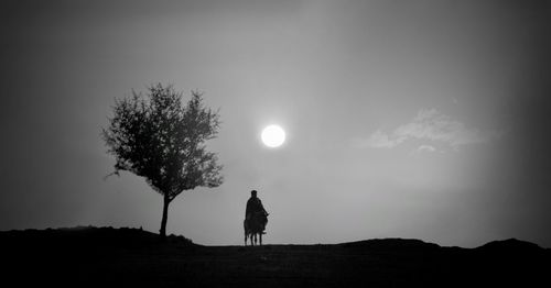 Silhouette person standing on field against sky