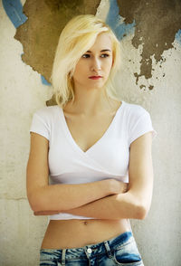 Portrait of beautiful woman standing against wall