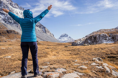 Full length of woman wearing padded jacket against sky