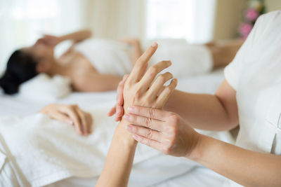 Midsection of woman lying on bed