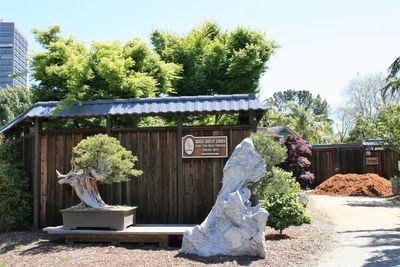 Statue against trees and house against sky