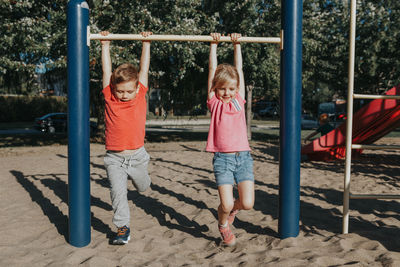 Full length of mother and girl standing on playground