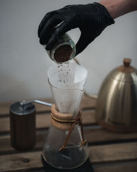 Close-up of hand pouring coffee in cup