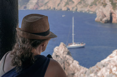 Rear view of woman wearing hat against sea