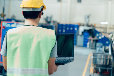 Rear view of man working in laptop