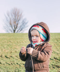 Close-up of cute girl wearing warm clothing standing on land