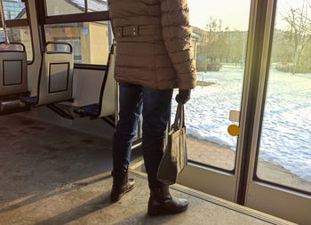 Low section of man standing by window