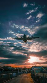 Low angle view of airport runway against sky during sunset