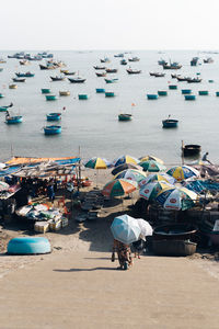 People on beach by sea against sky