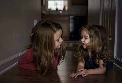 Sisters lying on floor at home