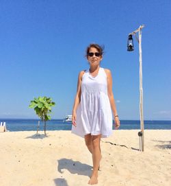 Full length of man standing on beach against clear sky