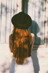 Rear view of woman wearing hat standing outdoors