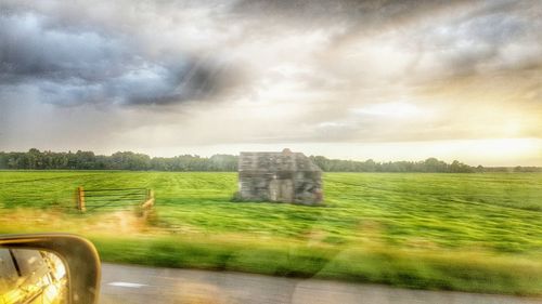 Scenic view of field against cloudy sky