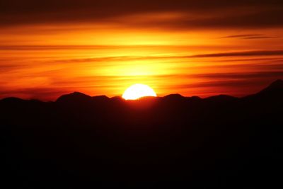 Silhouette of mountain against dramatic sky