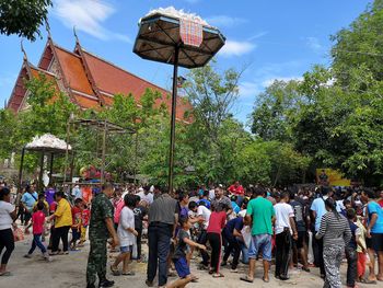 People on street against trees in city