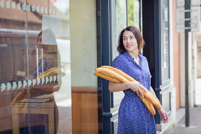 Young woman buying a french baguette