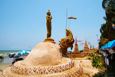 Statue against temple against clear sky