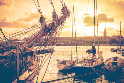 Old corsair ship and boats in the port of city saint malo at sunset, brittany, france