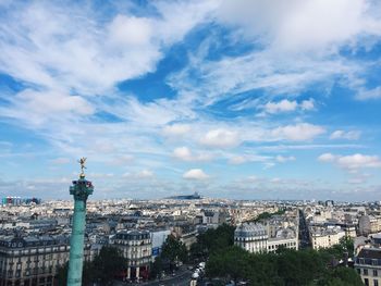 View of buildings in city against cloudy sky