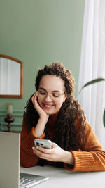 Portrait of young woman using laptop at home