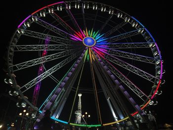 Low angle view of illuminated ferris wheel against sky at night