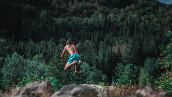 Full length of man jumping against trees