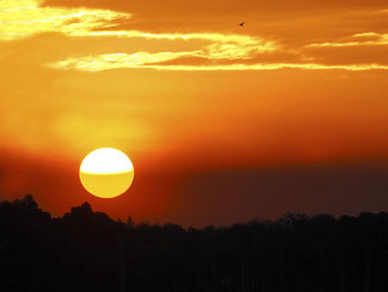 Scenic view of silhouette landscape against orange sky