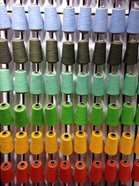 Full frame shot colorful thread spools on machine